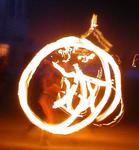 A fire-dancer swinging flames.