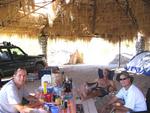 The guys hanging out under the shade of the palapa.