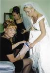 Cherie, Maid of Honor, slips the "something blue" garter on Michelle.