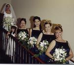 The bride (Tonya) and her bridesmaids walking down the stairs.