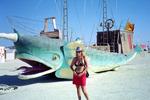 Typical girl (me) in a silver sequence cowboy hat and cherry bikini with a unicorn-fish car behind her.