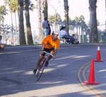 He comes down the final turn and finishes the bike ride with a smile just as big as the balloon's!