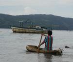 A local kid paddles out to a fishing boat to fetch us some ice.