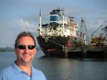 Nick-the-Greek with a Greek ship behind him.