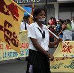 A young Panamanian girl marching with masking tape covering her mouth.  