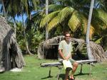 Greg taking a break on an authentic Kuna bench. (Original huts in the background.)