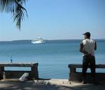 So close, but so far away.  A Cuban admires a yacht anchored off the coast.
