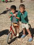 Two boys share a scooter.