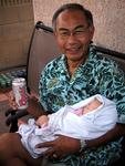 Eddy's hands are full with a beer and a baby.