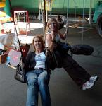 Carter and Kristi swinging around on tire swings.