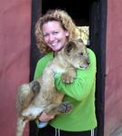 Cherie and a three month old lion cub.  They may be cute, but those claws are sharp!