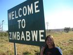 Cameras full of photos, bodies full of adrenaline, we head back to Zimbabwe.  (Renee by the boarder sign.)