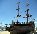 A pirate ship floats along the dusty desert floor.