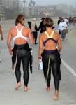 The swimmers walk to the starting point on the beach.