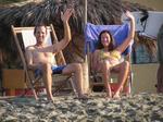 Greg and Bernadette wave from the comfort of their beach chairs.