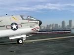 The A-7 Corsair II with the San Diego skyline in the distance.