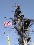 The flag proudly waves goodbye as the crew loosens the lines on the Midway. 