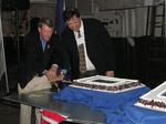 RADM Riley Mixson and Chairman Alan Uke make the first cut in the cake with a sword. 