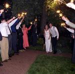 The newlyweds walk through a stream of sparkly lights.