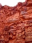 The jagged canyon wall looms over the hikers offering a bit of cool shade.