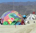 Colorful dome camps spring up like ripe desert fruit.