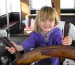 Ellie (5) sits in the Captain's chair on the Harbor Cruise near the Balboa Fun Zone, Newport Beach.