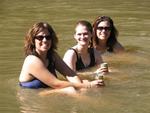 The ladies have a beer in the river.