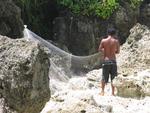 A fisherman untangles his net.