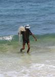 A fisherman wades through the waves.