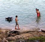 Kids playing by the water-buffalo.