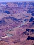 The blue Colorado River snakes through the red granite of the canyon.