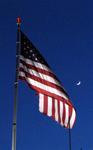 The American Flag waves at the moon.