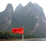 China's red flag framed by Guilin's karst hills.