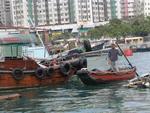 A boater navigates through the crowded mess of boats.