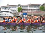 The paddlers glide past multi-million dollar homes.