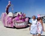 Alice (Margaret) and her Tea Party (Cherie) meet a giant Cheshire Cat at Burning Man.
