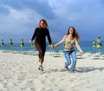 Cherie and Giuliana skipping down the beach.