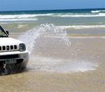 A fountain of water arches off the tires.