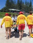 Some might think it would be romantic to be carried up the beach by a bunch of cute guys...but not in a c-collar.