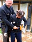 Marsell helps fir Crystal with her caving gear.
