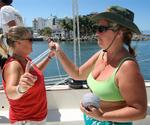 Britta and Anne prepping yarn ties for the spinnaker. *Photo by Karen Vaccaro S/V Miela.