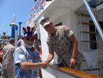 Newport Beach Mayor Don Webb welcomes US Marine Josh Rynders aboard the Defever 52 donated by Horizon Yachts.