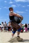 A big man, a big blue sky, and a big bag of sand.