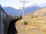 The train snakes across New Zealand from the plains of Canterbury to the valleys of the Waimakariri River, through the peaks of the Southern Alps.