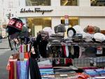 Vendors hawk their wares in front of designer shops on 5th Avenue.