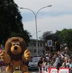 The sponsors of the Tour de France drive by in colorful "gift-bearing" vehicles.