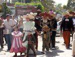 The caballeros dismount and prepare to enter the church.