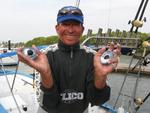 A local fisherman proudly shows off the squid's huge eyes.