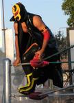 This masked Mexican wrestler (or luchador) is about to jump into the crowd.  