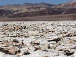 Salt flats (not flat) dwarfed by the mountains.